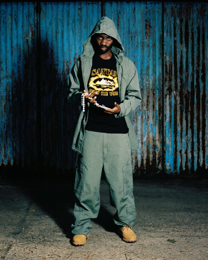 Santan Dave holding his chain wearing CORTEIZ